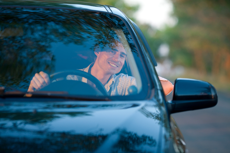 一个微笑的男人从侧车窗外望去