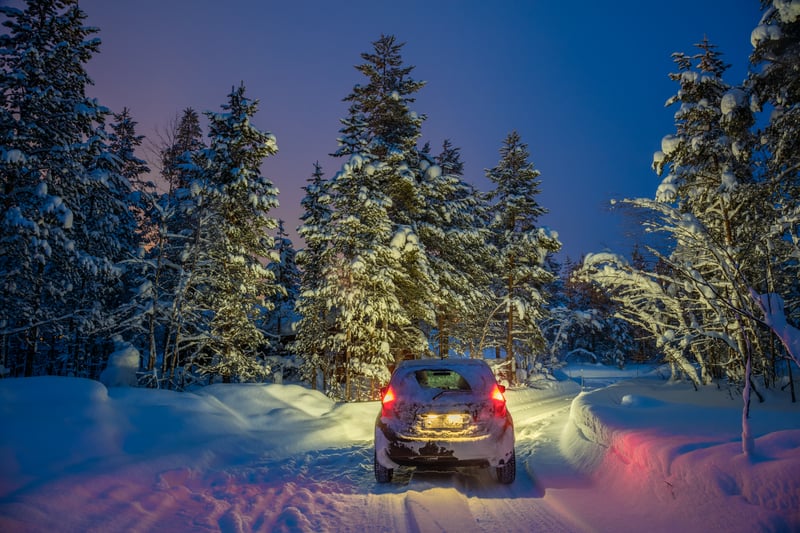 冬天晚上在雪路上行驶的汽车
