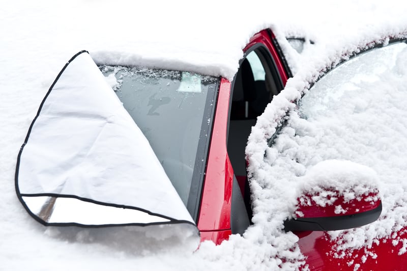 带有挡风玻璃罩的汽车，可防止挡风玻璃上的雪和冰