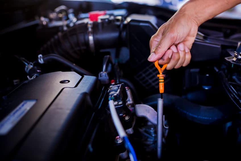 检查汽车发动机中的油位 — 机械师检查汽车发动机