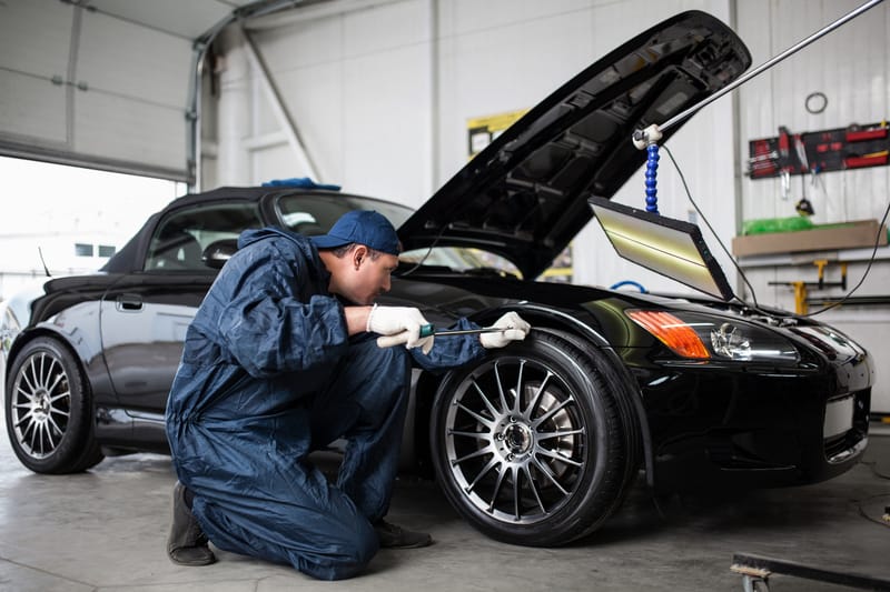 修理本田 S2000 跑车前挡泥板上凹痕的机械师