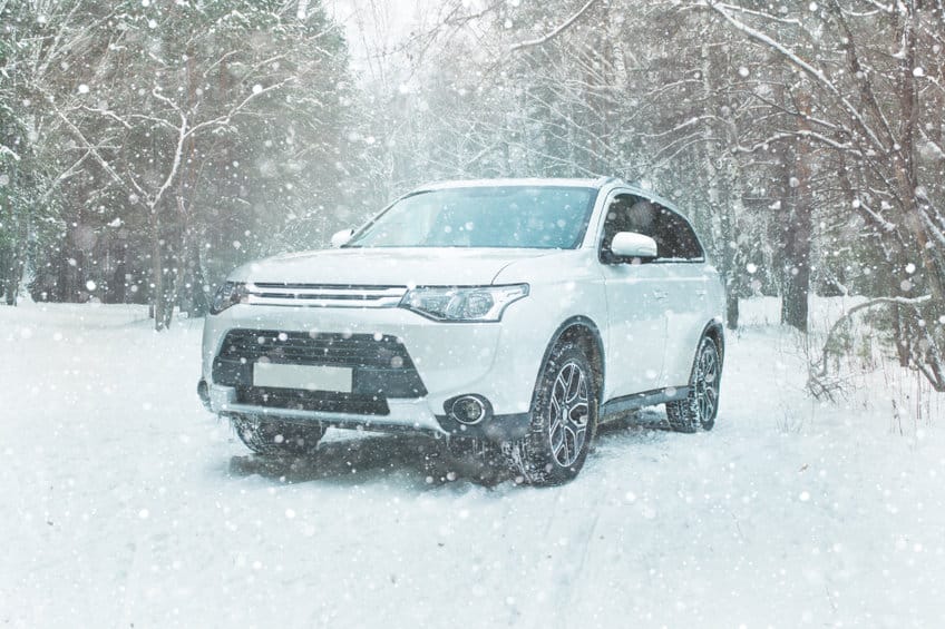 在雪地越野的白色SUV在森林里