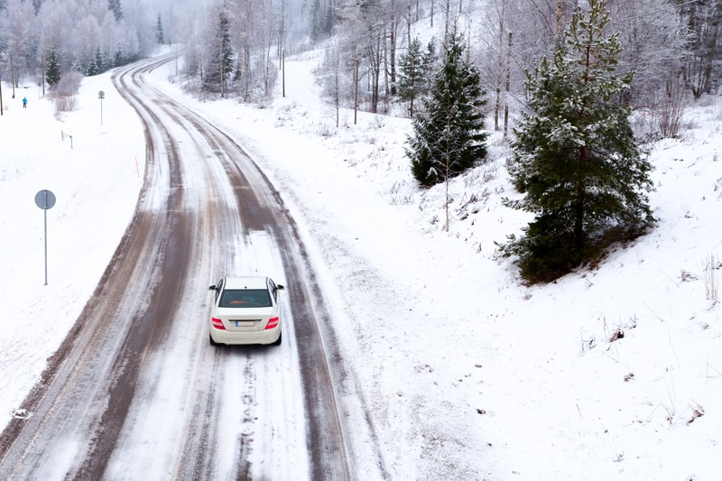 冬天在雪路上行驶的白色汽车